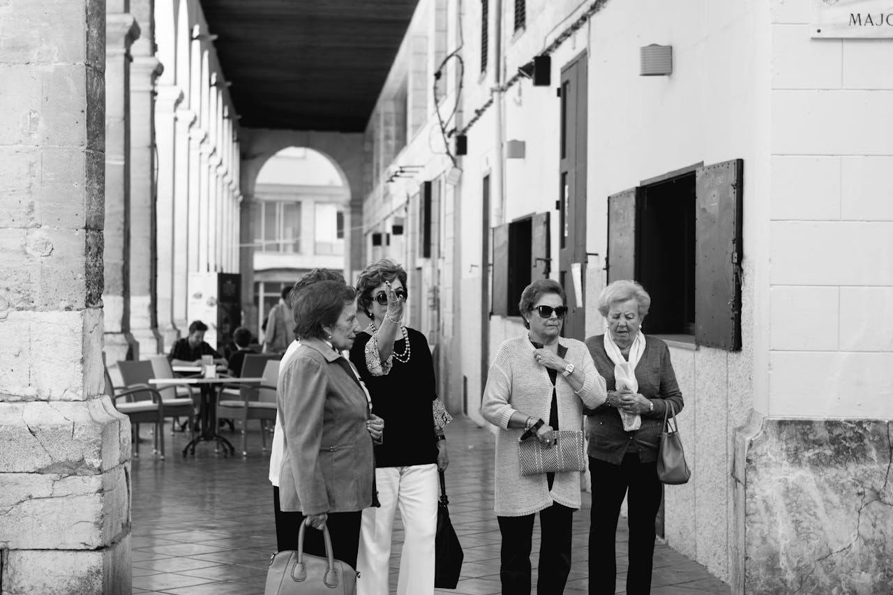 about-01 Four senior women enjoying a leisurely day in a cityscape setting, embracing urban life.